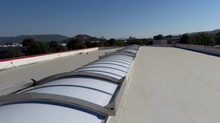 Vue de la toiture du bâtiment AVIS à Clermont-Ferrand après la réfection complète, avec nouvelle étanchéité PVC et voûtes de désenfumage posées